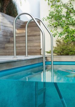 Metal ladder in a swimming pool outdoors