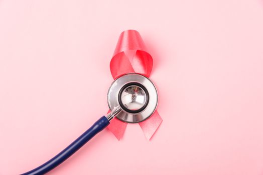 Breast Cancer Awareness Month Health concept, top view flat lay pink ribbon and stethoscope on pink background with copy space for your text