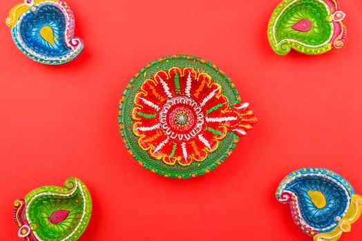 Happy Diwali Day, Flat lay top view Colorful Clay Diya lamps on red background and copy space for your text