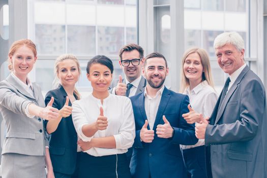Portrait business people team showing thumbs up , office staff standing in lobby