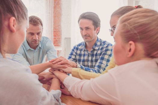 Business people putting their hands on top of each other stacking at conference