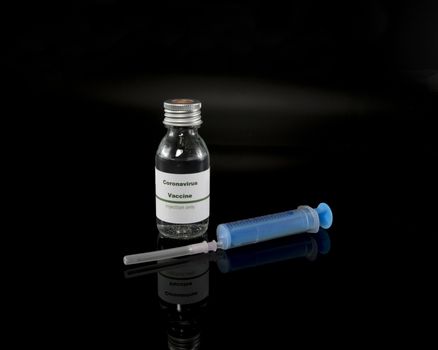 Coronavirus vaccine vial with injection syringe isolated on black background