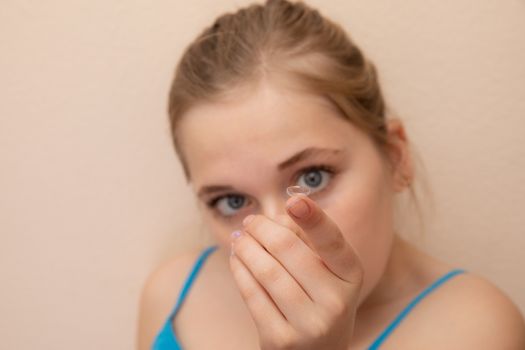 Young girl who is ready to wear a contact lens for vision correction