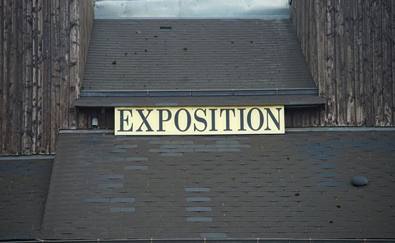Sign Exposition on black wooden and tiled rooftop