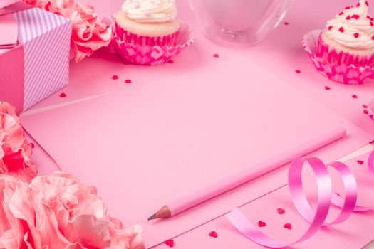 Valentines day pink background with blank love letter with copy space gift box rose flowers cupcakes pencil and drink