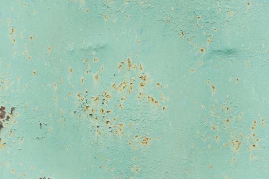 Multicolored background: old rusty metal surface with light blue paint flaking and cracking texture