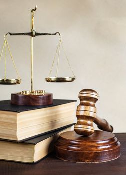 Symbols of law: wood gavel, soundblock, scales and two thick old books