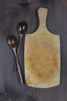 Vintage cutting board with space for text and two wooden spoons