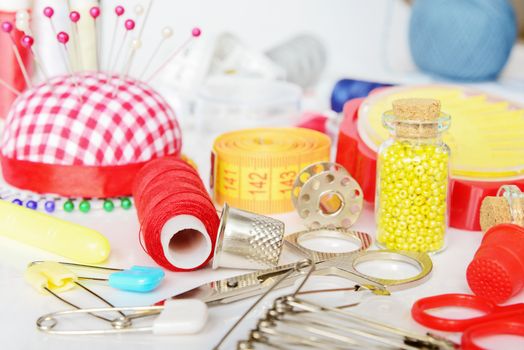 Sewing kit: threads, needles, pins, scissors, beads, centimeter tape etc.