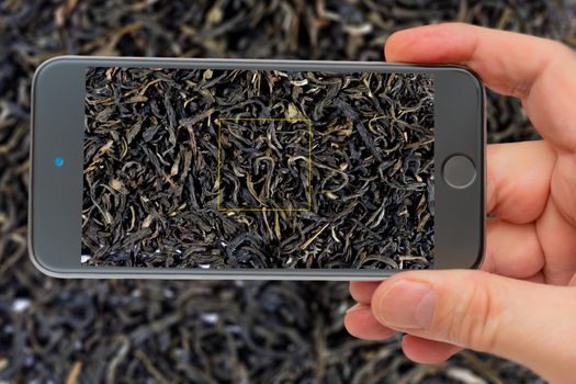 Black tea for making a refreshing drink. Textures of black tea. Black tea on the smartphone screen.