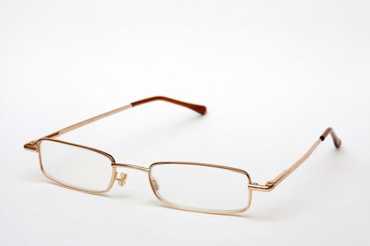 Glasses in thin metal frame on white background. Vision correction.