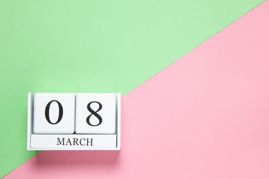 Perpetual calendar with date of March 8 on two-color background pink and green. Flat lay. Top view. International Happy Women's Day celebration concept. Horizontal, close-up, copy spase. For delivery.