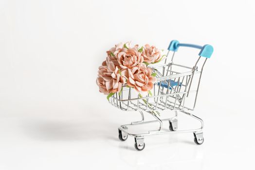 shopping cart full of roses flower on white background