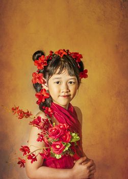 Cute asian little girl with wreath of flowers on her head