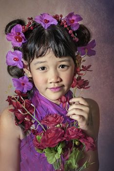 Cute asian little girl with wreath of flowers on her head