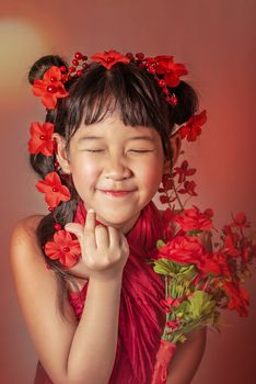 Cute asian little girl with wreath of flowers on her head