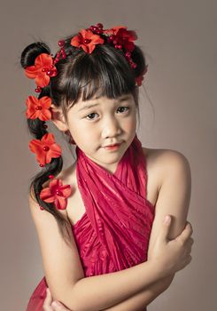 Cute asian little girl with wreath of flowers on her head