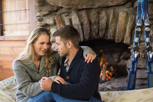 Lovely romantic young couple in front of lit fireplace
