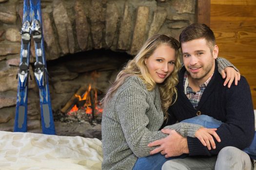 Portrait of a lovely romantic young couple in front of lit fireplace