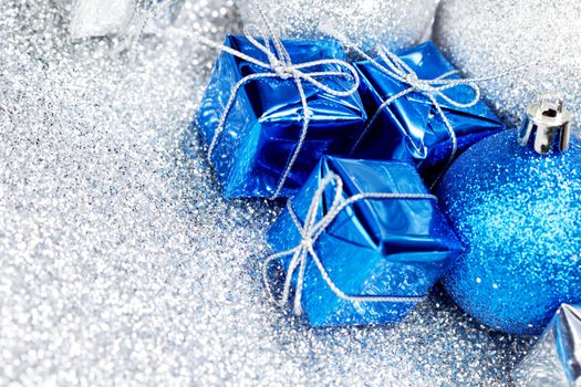 Decorative Christmas balls and gifts on silver bokeh background