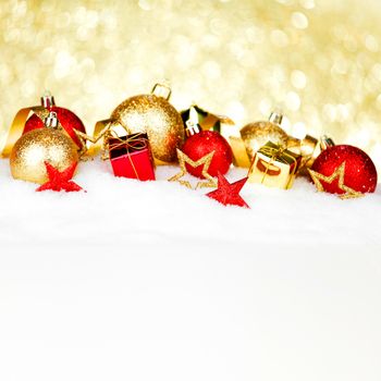 Red and golden christmas balls and decoration on snow