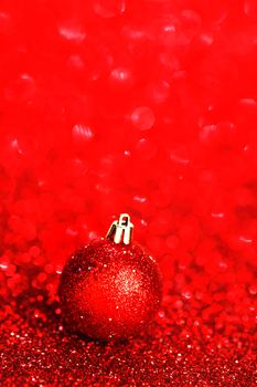 Beautiful red christmas ball on abstract glitter background close-up