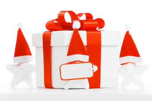 White gift box with red ribbon, stars with santa claus hats isolated on white background