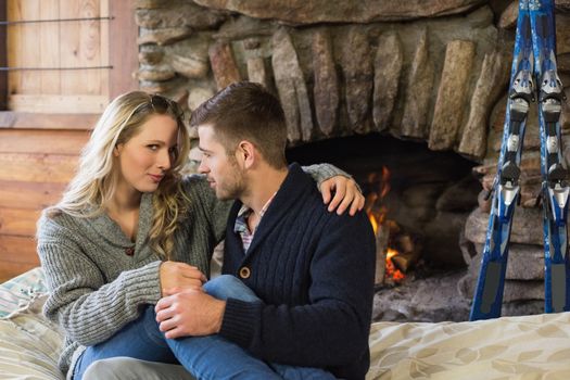 Lovely romantic young couple in front of lit fireplace