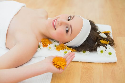 Side view portrait of a beautiful young woman with flowers in beauty salon