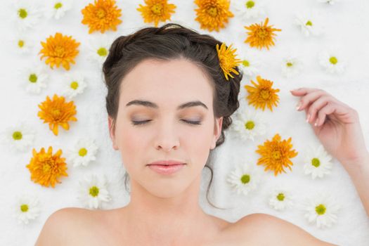 Close up of a beautiful young woman with flowers in beauty salon