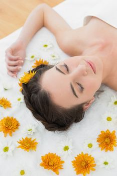 Close up of a beautiful young woman with flowers in beauty salon