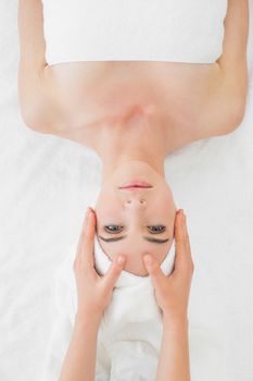 Close up of hands massaging a beautiful womans face at beauty spa