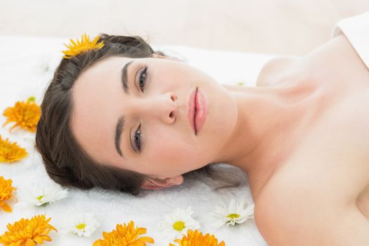 Close up portrait of a beautiful young woman with flowers in beauty salon