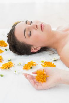 Close up of a beautiful young woman with flowers in beauty salon