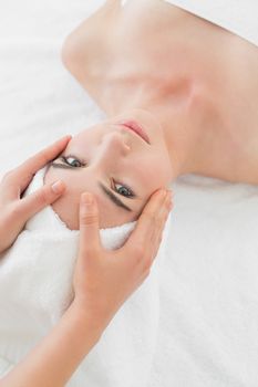 Close up of hands massaging a beautiful womans face at beauty spa