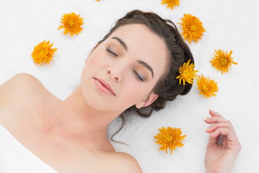 Close up of a beautiful young woman with flowers in beauty salon