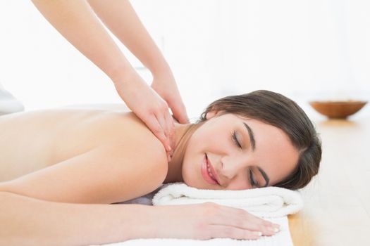 Close up of a beautiful woman enjoying neck massage at beauty spa