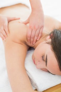 Close up of a beautiful woman enjoying shoulder massage at beauty spa