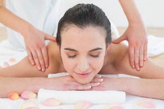 Close up of a beautiful woman enjoying shoulder massage at beauty spa