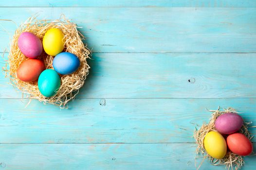 Easter concept. Colorful eggs on blue wooden background with copy space for text. Top down view or flat lay