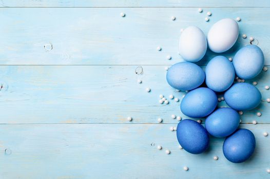 Easter concept. Ombre eggs in blue colors on blue wooden background with copy space for text. Top down view or flat lay. Classic blue colors in Easter 2020