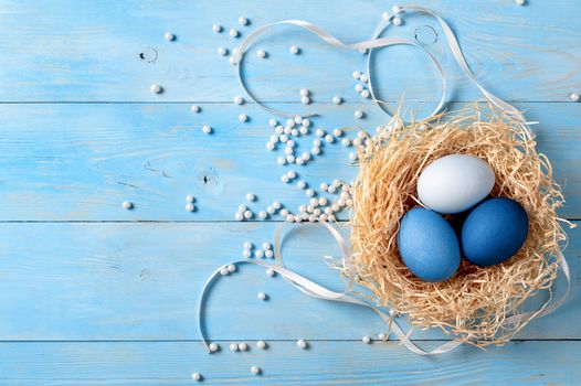 Easter concept. Ombre eggs in blue colors on blue wooden background with copy space for text. Top down view or flat lay. Classic blue colors in Easter 2020