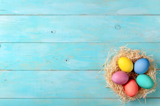 Easter concept. Colorful eggs on blue wooden background with copy space for text. Top down view or flat lay