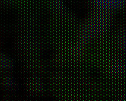 abstract background pattern of colored blurry dots on a dark background close up