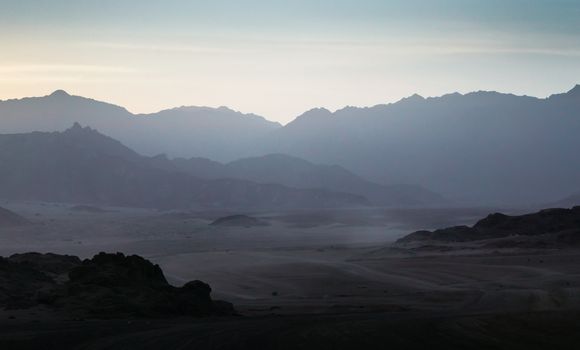 night desert landscape with rocky mountains and sunset sky with clouds in Sharm El Sheikh Egypt