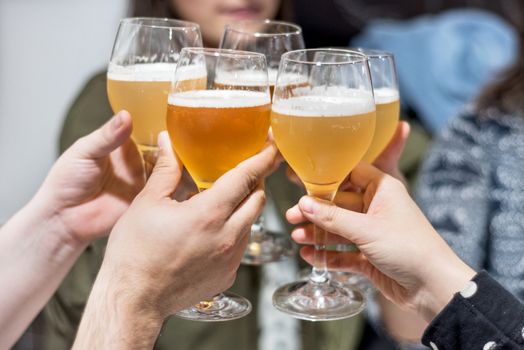 Group of friends drinking beer, toasting, at pub