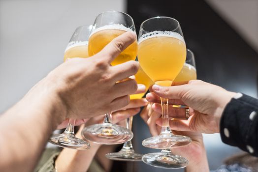 Group of friends drinking beer and toasting, at pub