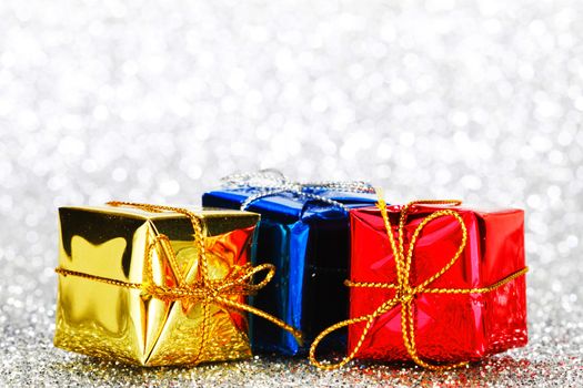 Decorated holiday gifts on silver background