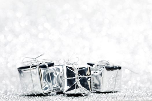 Decorated holiday gifts on silver background