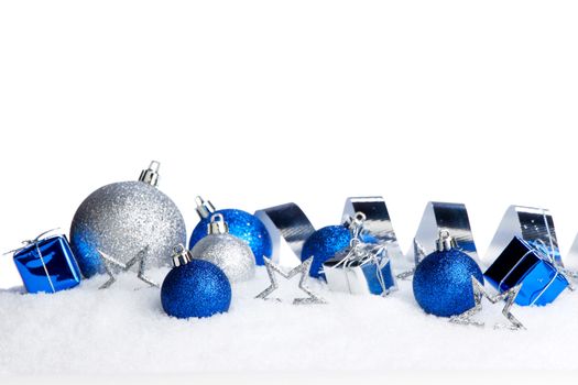 Silver and blue Christmas decorations on snow close-up